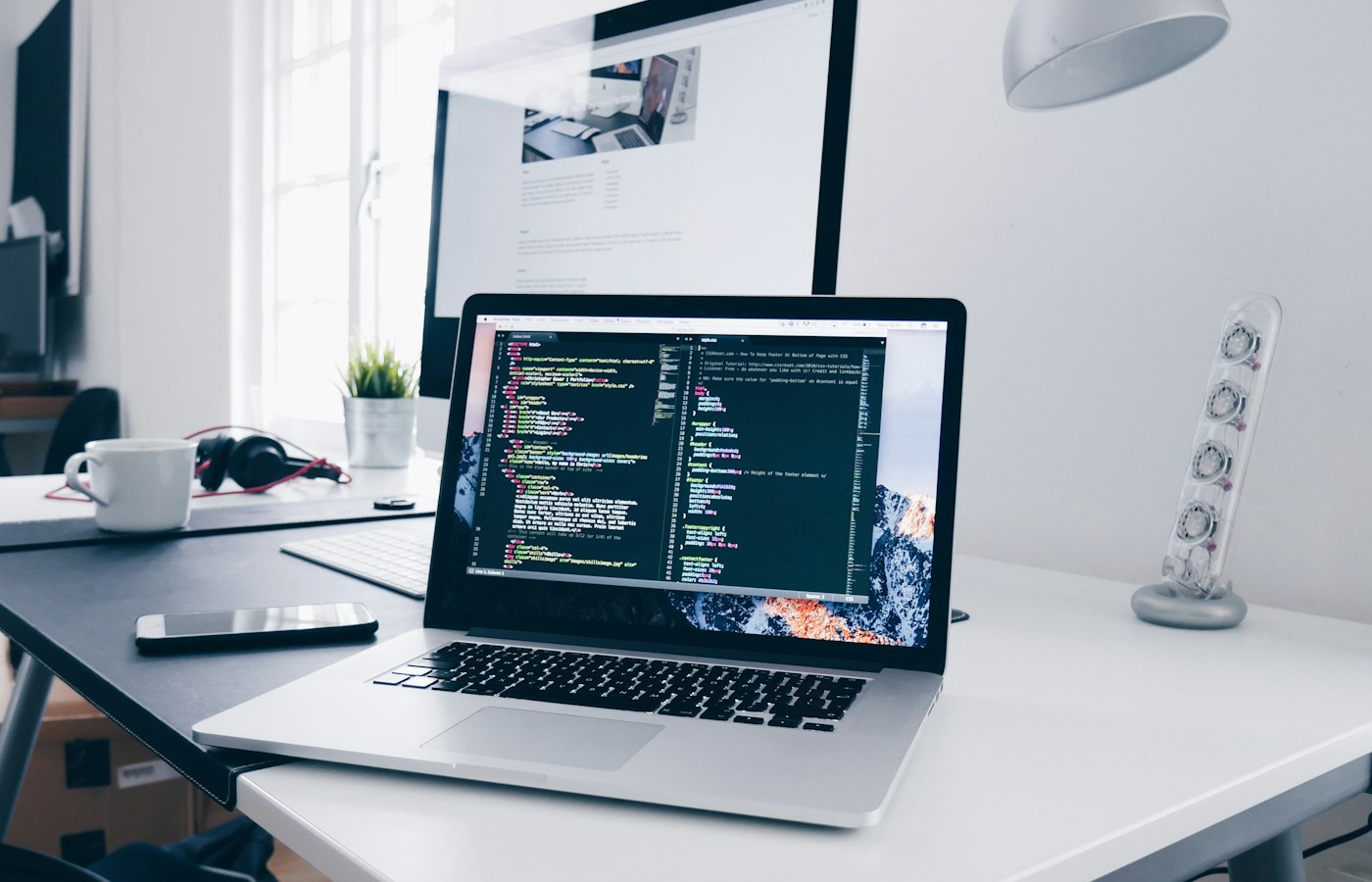 A website open beside the code that builds it
